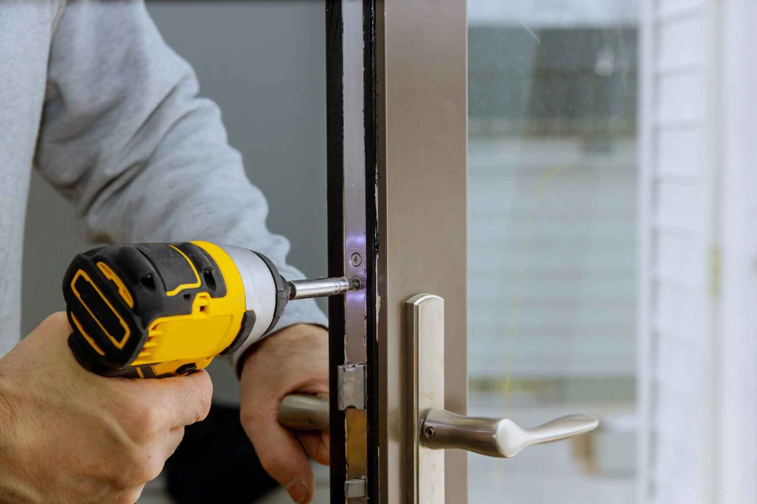 locksmith-in-installing-new-house-door-lock-hand-h-XVHVTG4.jpg